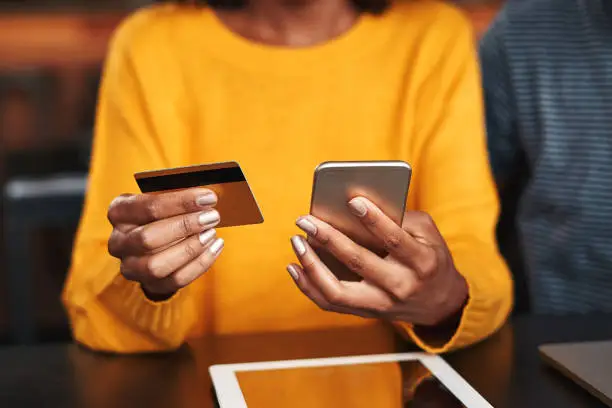 A woman making payment with her phone || National Instant Payment System